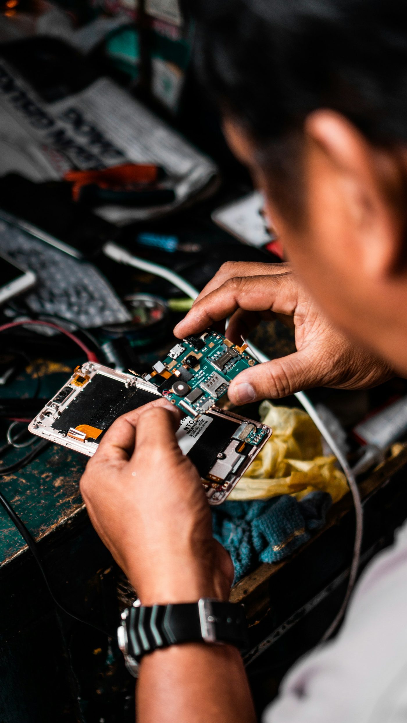 A technician repairing a smartphone